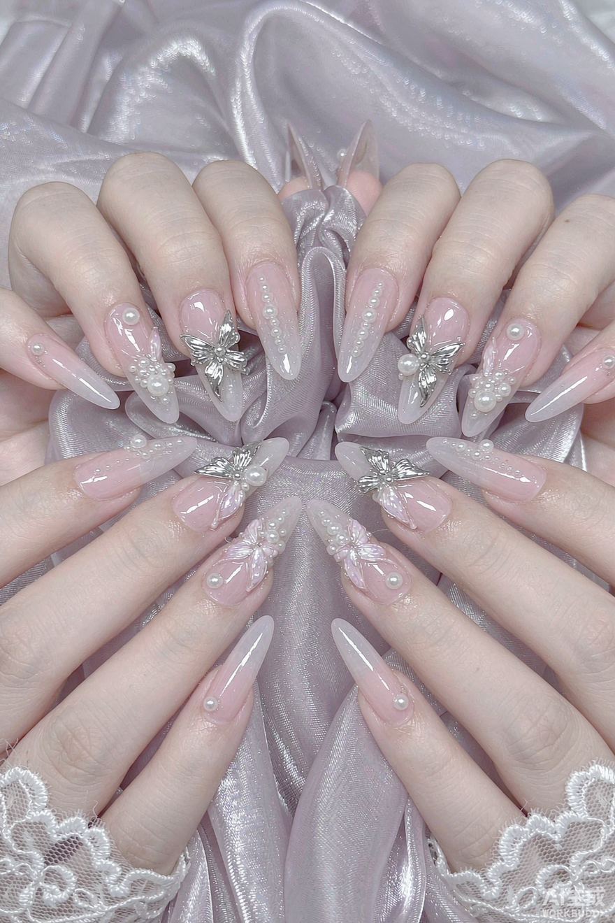 Sheer almond nails with three-dimensional butterfly charms and pearls